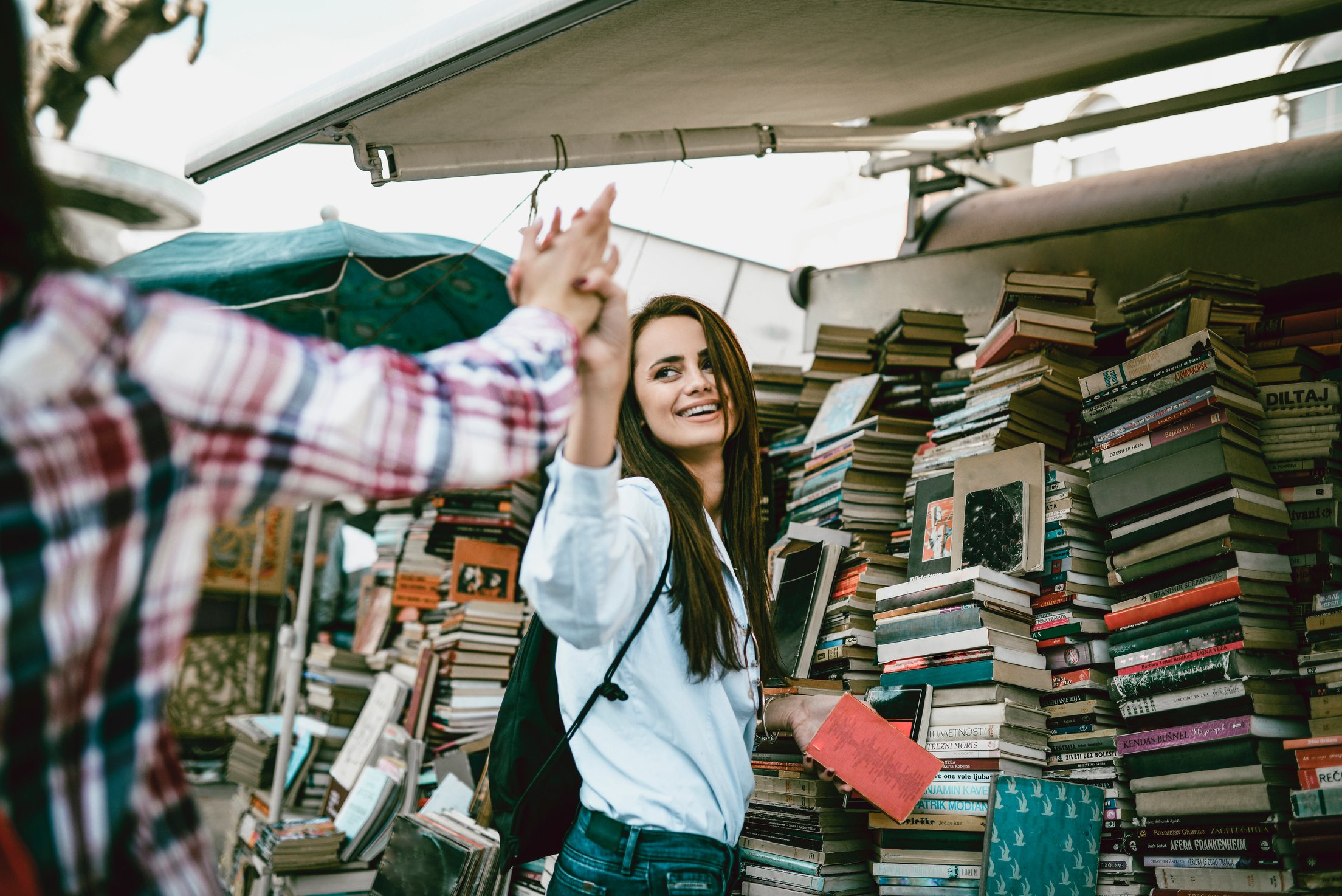 Two Female Friends Greeting Each Other At A Book Fair